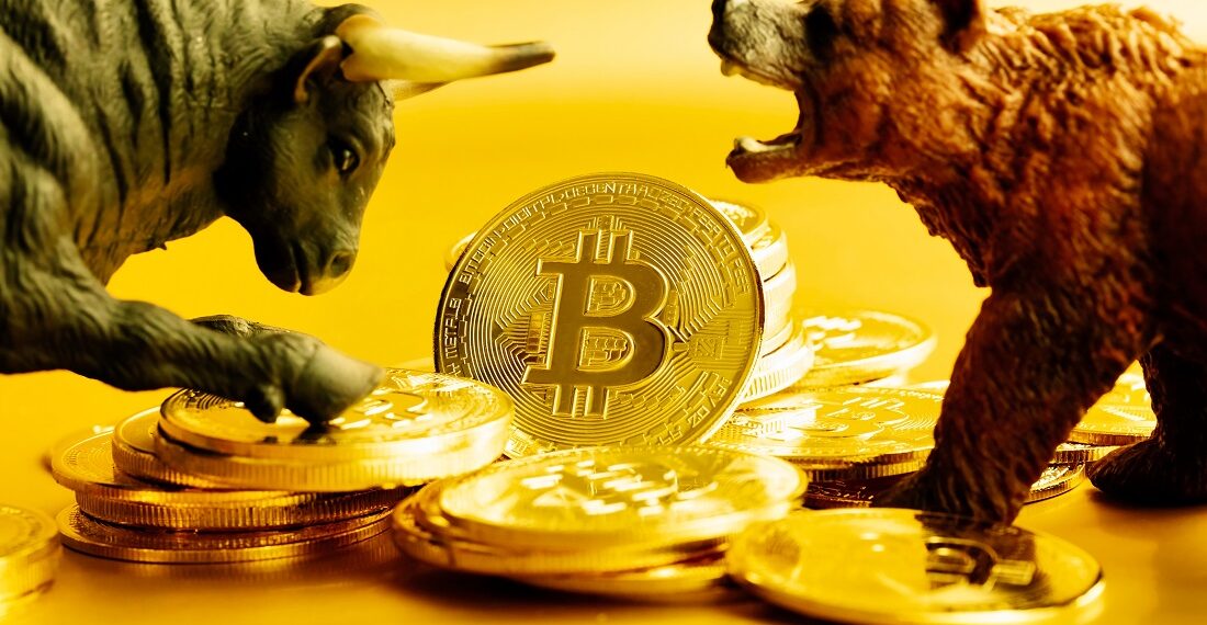 Un toro, una moneda física de bitcoin, y un oso.