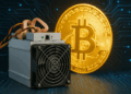 Una moneda dorada brillante de Bitcoin junto a un dispositivo de minería de color gris y negro, con un fondo oscuro tecnológico.