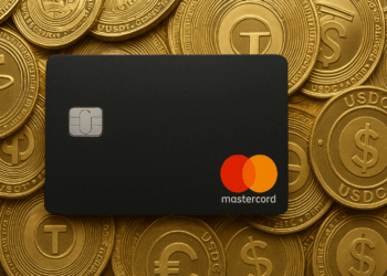 Tarjeta negra de Mastercard apoyada sobre un conjunto de monedas doradas que representan las stablecoins USDT y USDC, con sus logotipos grabados en relieve.
