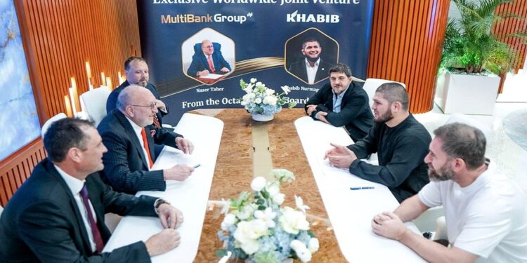 Grupo de hombres de negocio sentados alrededor de una mesa conversando.