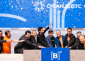 Personas celebran frente al logo de B3, la bolsa de valores más antigua de Brasil.
