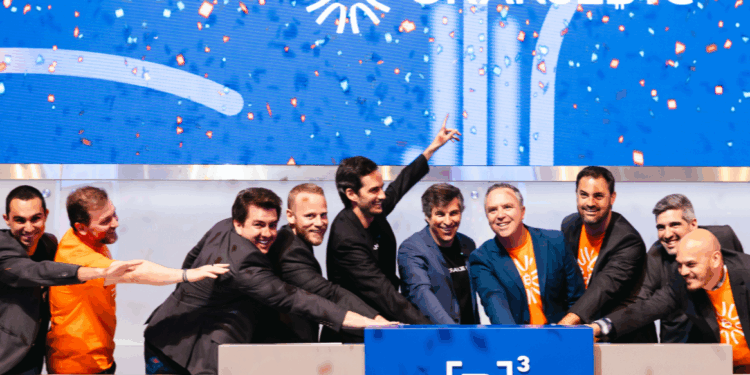 Personas celebran frente al logo de B3, la bolsa de valores más antigua de Brasil.