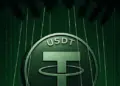 Logo de USDT impreso en una moneda física, en un fondo de color verde oscuro.