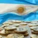 Bandera Argentina sobre varias monedas con el logo de BTC.