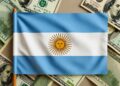 Bandera de Argentina sobre varios billetes de 100 dolares.