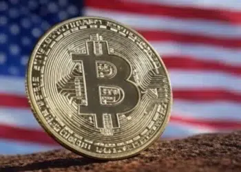 Logo de bitcoin frente a una bandera de Estados Unidos.