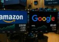Fotografía del interior de Wall Street con pantallas que muestran los precios de Amazon y Google.