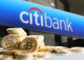 Fachada del edificio de Citibank con unas monedas de bitcoin doradas al frente.