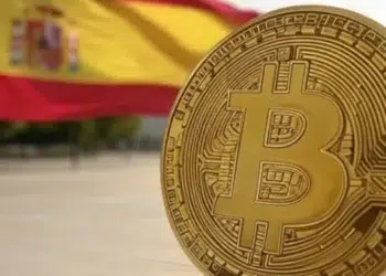Logo de Bitcoin frente a una bandera de España.