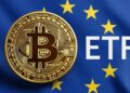Una moneda en físico de bitcoin con un fondo de la bandera de la Unión Europea y al lado de la moneda las letras ETF.