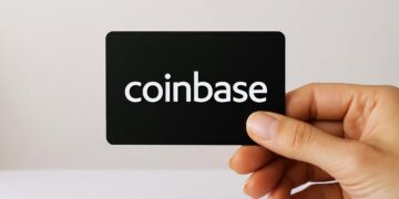 Una tarjeta negra con el nombre de Coinbase sostenida por una mano.