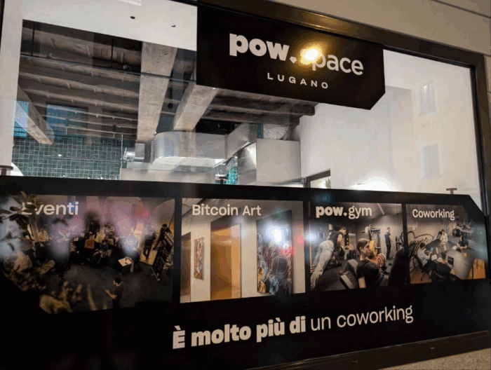 Fachada del Pow Space en Lugano con anuncios sobre gimnasio, eventos, arte y coworking.