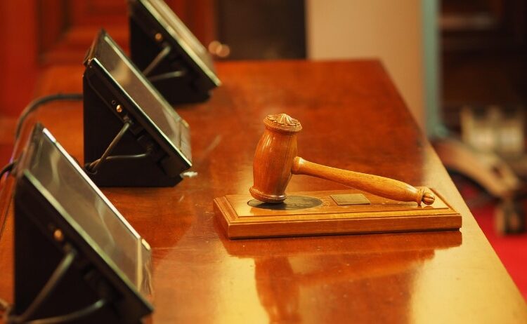 Fotografía de una sala de juicio con un mazo de juez.