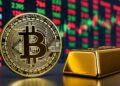 Moneda de bitcoin dorada junto con un lingote de oro y un fondo bursátil.