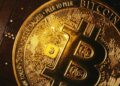 Moneda física de bitcoin sobre una tarjeta electrónica.