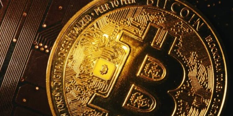 Moneda física de bitcoin sobre una tarjeta electrónica.