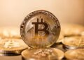 Monedas físicas de bitcoin doradas sobre un escritorio.
