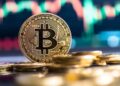 Moneda física de bitcoin dorada sobre un escritorio.