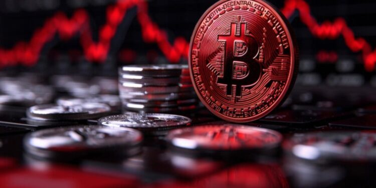 Moneda física de bitcoin dorada con otras monedas apiladas y un fondo de gráficas rojas.