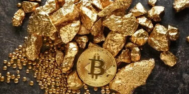 Una moneda física de bitcoin dorada rodeada de trozos de oro sobre una mesa.