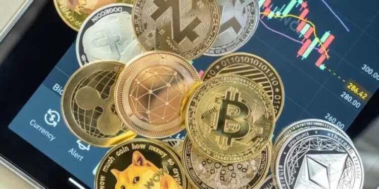 Monedas físicas de bitcoin, xrp, ethereum, doge, cardano, sobre una tablet.
