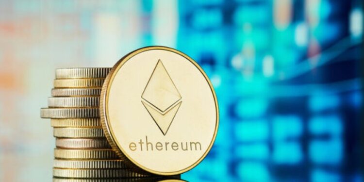 Moneda física de ETH dorada sobre un escritorio con un fondo azul.