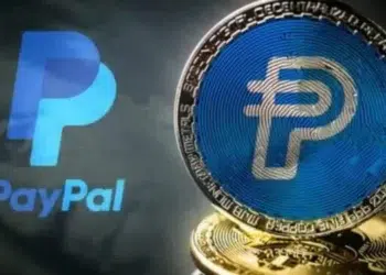 Logo convencional de Paypal y de una moneda fisica sobre la misma empresa.