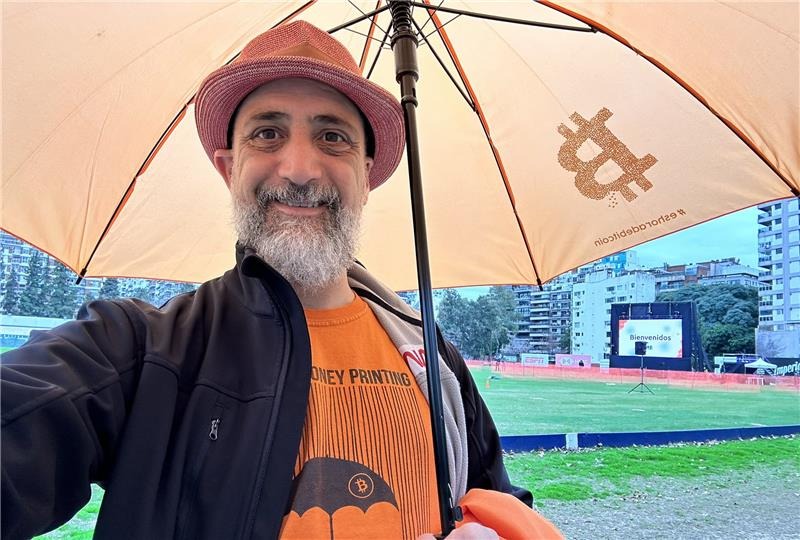 Rodolfo Andragnes, founder of Bitcoin Argentina, with an umbrella that has the bitcoin logo.
