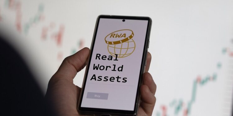 Un celular muestra en su pantalla las palabras Real World Assets.