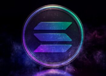 Moneda física de solana con sus colores característicos, verde, azul y morado, con un fondo negro.