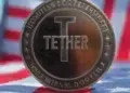 Moneda con la escritura "Tether" por delante de una bandera con los colores de Estados Unidos.