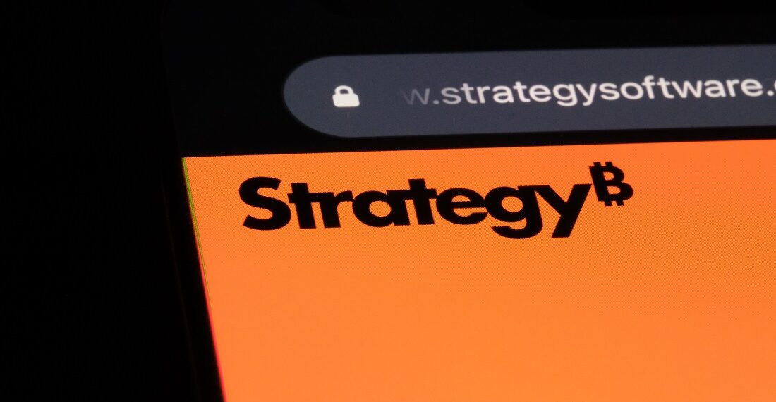 Logo de Strategy en la pantalla de un móvil con un fondo negro.