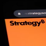 Logo de Strategy en la pantalla de un móvil con un fondo negro.