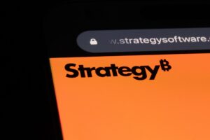 Logo de Strategy en la pantalla de un móvil con un fondo negro.
