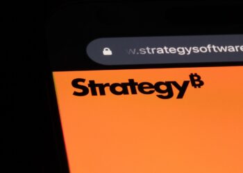 Logo de Strategy en la pantalla de un móvil con un fondo negro.