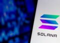 Teléfono mostrando el logo de solana con un fondo azul.