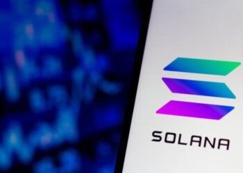 Teléfono mostrando el logo de solana con un fondo azul.