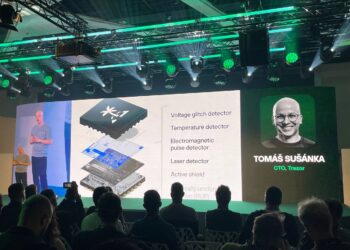 Presentación Trezor en conferencia. Su CTO Tomáš Šůsánka muestra chip K1 con detectores voltaje, temperatura y láser para seguridad blockchain