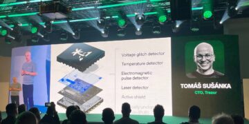 Presentación Trezor en conferencia. Su CTO Tomáš Šůsánka muestra chip K1 con detectores voltaje, temperatura y láser para seguridad blockchain
