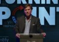 El periodista Tucker Carlson dando una presentación.