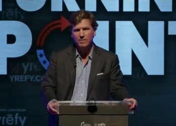 El periodista Tucker Carlson dando una presentación.