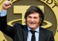 Imagen realista del presidente argentino Javier Milei en pose triunfante, levantando el puño con una sonrisa victoriosa, frente a un fondo con una gran moneda dorada de USDT (Tether), evocando temas de economía y criptomonedas.