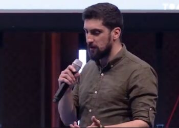 Amir Taaki en primer plano ofreciendo una conferencia sobre bitcoin.