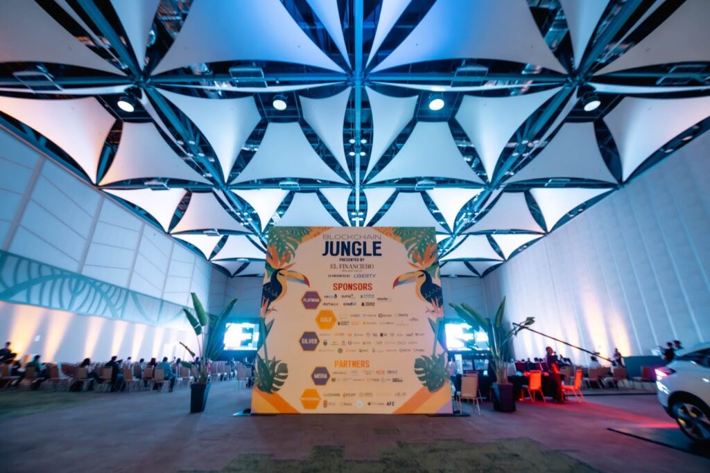Salón de evento Blockchain Jungle 2025 - Costa Rica y pendón con los sponsors