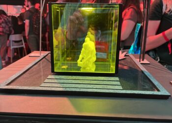 Escultura a escala de Satoshi Nakamoto dentro de un cubo.