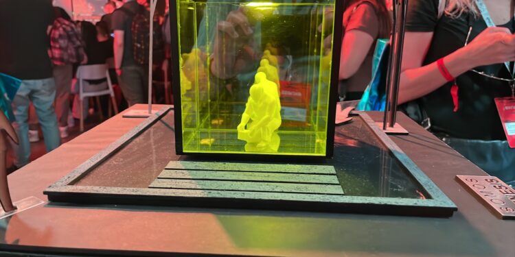 Escultura a escala de Satoshi Nakamoto dentro de un cubo.