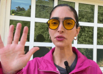 Alejandra Guajardo, Miss Bitcoin de El Salvador, con chaqueta rosa y anteojos amarillos.