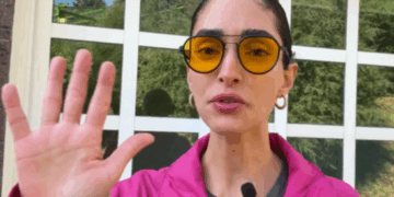 Alejandra Guajardo, Miss Bitcoin de El Salvador, con chaqueta rosa y anteojos amarillos.