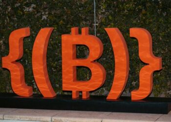 Nuevo logo deONG Bitcoin Argentina, símbolo de bitcoin en color naranja como decorativo en evento.