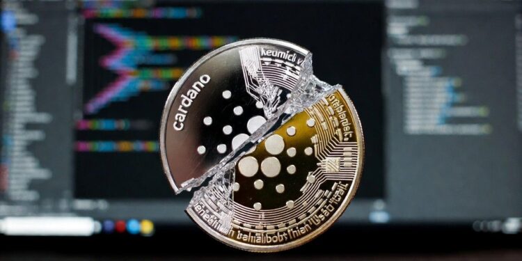 Una moneda digital e Cardano partida en pedazos con un fondo de una pantalla de una computadora.